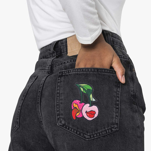 Patch featuring two cherries with expressive lips, one with a tongue sticking out, set against a white background. The design is playful and vibrant, combining bold colors with a fun, cheeky style.